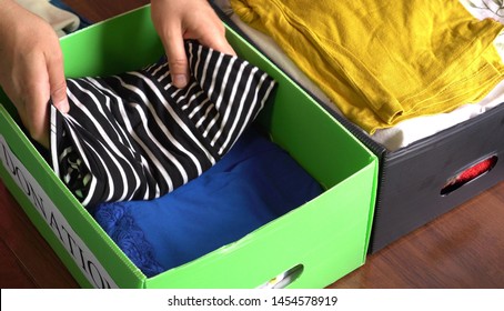 Female volunteer collects donation boxes with  used clothing. Men's, women's and children's old clothes and accessories. Charity Recycling Service. Textile Recycle and Donate