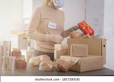 Female Volunteer Working In Food Bank Warehouse. Woman Is Sorting Food And Gift. Helping Poor And Needy People. Donation Concept.