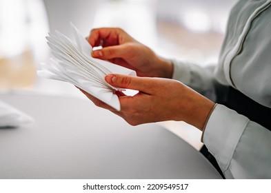 Female Waiters Hand Folding Paper Napkins In Restaurant