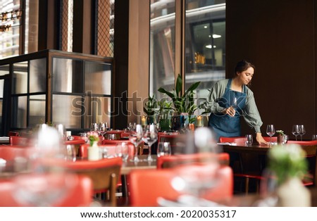 Female waitress setting tables in restaurant  商業照片 © 