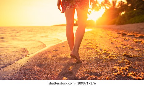 Female walking down a beach during a beautiful golden sunset. Tropical nature getaway concept.  - Powered by Shutterstock