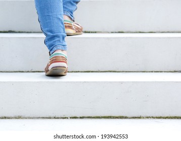 Female walking upstairs on stone staircase outdoors