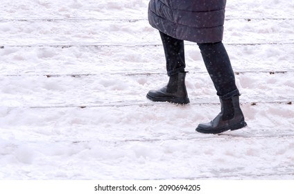 Female walks up stairs with snow steps during snowfall. Woman climbs snow covered staircase. Person climbing slippery snowy stairs. Dangerous winter walking. Selective Focus
 - Powered by Shutterstock