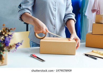 female warehouse worker are checking or seller packing ecommerce shipping order box for dispatching, preparing post courier delivery package or online sales, e-commerce concept.