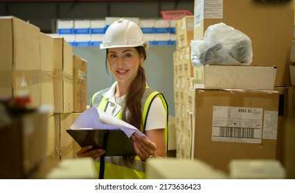 Female Warehouse Worker Counting Items In An Industrial Warehouse On The Factory's Mezzanine Floor. Which Is A Storage For Small And Light Electronic Parts.