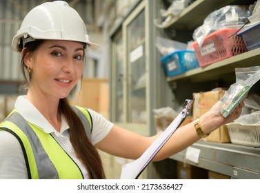 Female Warehouse Worker Counting Items In An Industrial Warehouse On The Factory's Mezzanine Floor. Which Is A Storage For Small And Light Electronic Parts.