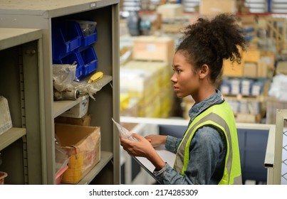 Female Warehouse Worker Counting Items In An Industrial Warehouse On The Factory's Mezzanine Floor. Which Is A Storage For Small And Light Electronic Parts.