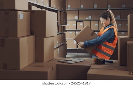 Female warehouse worker lifting a heavy delivery box, her back is hurting - Powered by Shutterstock