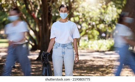 Female Wearing Covid Mask Cleaning The Park For A Clean, Hygiene And Safe Green Outdoor Environment. Community Service, Volunteers Or Activist Workers With Rubbish, Trash And Garbage In A Plastic