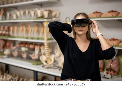 Female wearing HoloLens headset learning anatomy and physiology concepts in a medicine and health science laboratory. Visualising virtual world using hologram technology. Close up standing photograph. - Powered by Shutterstock