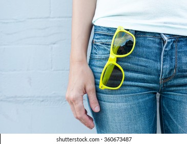 Female Wearing Jeans Wit Pair Of Sunglasses In Pocket. (Fashion Concept)