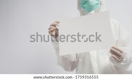 Female wearing PPE or Personal Protective Equipment and face mask and two hand with gloves is holding A4 paper on white background.