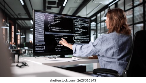 Female Web Developer Working On Software Code At Office Desk