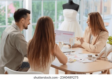 Female wedding planner working with couple in office - Powered by Shutterstock