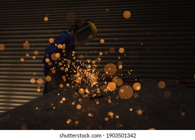 Female welder using welding torch in workshop - Powered by Shutterstock