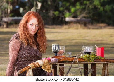 Female Wicca Priestess With Staff And Goblets On Altar