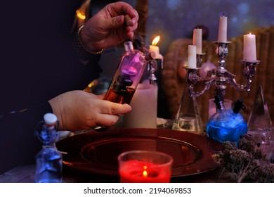 Female Witch, Alchemist Holds Bottle With Elixir Of Life In Her Hands, Conjures In Dark Room, Magic Items, Concept Of Halloween Party, Alternative Medicine, Esoteric Practices In Salon Of Medium