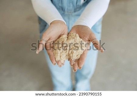 Female woodworker holding a pile of sawdust