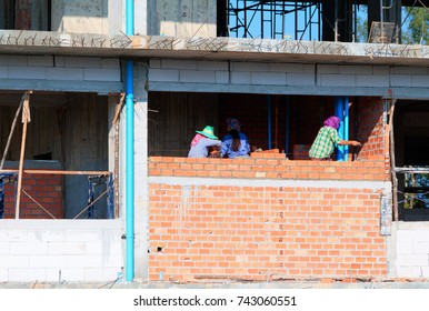 Female Worker Bricklayer Laying Brick A Wall Construction In Industrial  Building Site