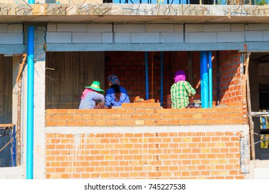 Female Worker Bricklayer Laying Brick A Wall Construction In Industrial  Building Site