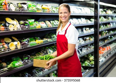 Female Worker Carrying Vegetables Box In Grocery Store