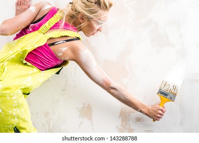 Female Worker In Coverall Paint A  Wall