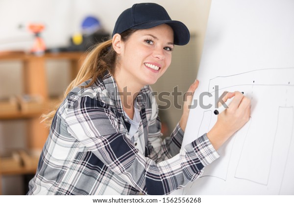 female worker\
drawing designs on white\
board