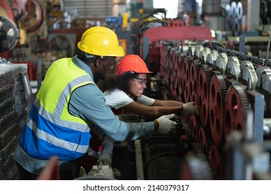 Female worker feeling very pain in accident her arm got stuck in  machine while working in factory. Male engineer colleague is helping.Safety First Aid Concept.