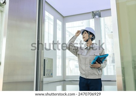 Female worker inspecting the elevator