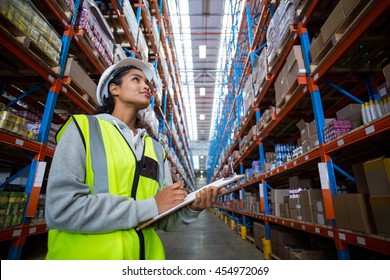 Female worker looking up in warehouse