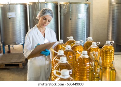 Female worker maintaining record in notepad at factory - Powered by Shutterstock