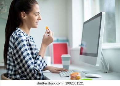 Female Worker In Office Having Healthy Snack Of Dried Apricot Fruit