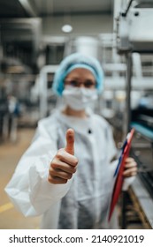 Female Worker With Protective Face Mask Working In Medical Supplies Research And Production Factory And Checking Canisters Of Distilled Water Before Shipment. Inspection Quality Control. 