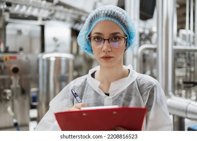 Female Worker In Protective Workwear Working In Medical Supplies Research And Production Factory And Checking Canisters Of Distilled Water Before Shipment. Inspection Quality Control. 