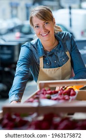 A Female Worker Selling Strawberries