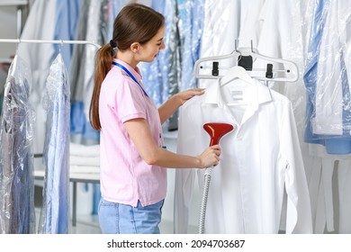 Female Worker Steaming Clothes At Modern Dry-cleaner's