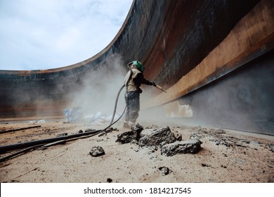 Female worker surface corrosion plate preparation by sand blasting of tank internal oil