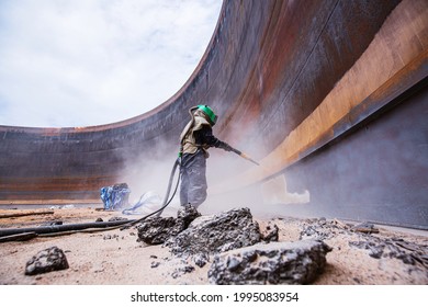 Female worker surface corrosion plate preparation by sand blasting of tank internal oil