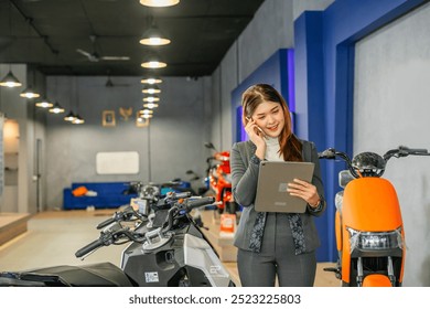 female worker talking on a phone while looking at digital tablet at electric bicycle display store - Powered by Shutterstock