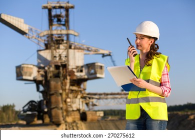 female worker talking on a radio on a background of career Stacker