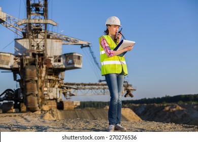 female worker talks on the walkie-talkie on a background of career Stacker