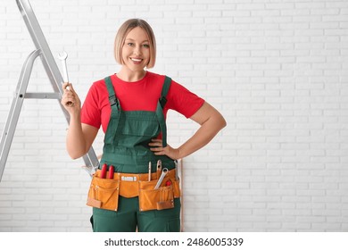 Female worker with tools belt in room - Powered by Shutterstock