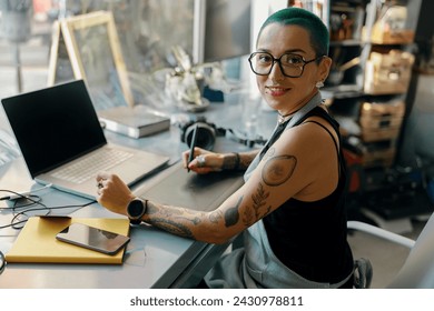 Female worker uses graphics tablet and laptop for retouching photos or digital drawing in studio - Powered by Shutterstock