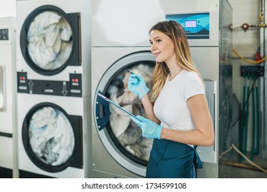 Female Worker Working With The Laundry, She Is Operating With Industrial Washing Machine.