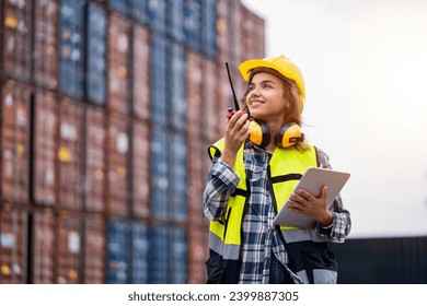 Female workers in the container industry transporting imports and exports of goods to the shipping business. Confident engineer in container terminal. - Powered by Shutterstock