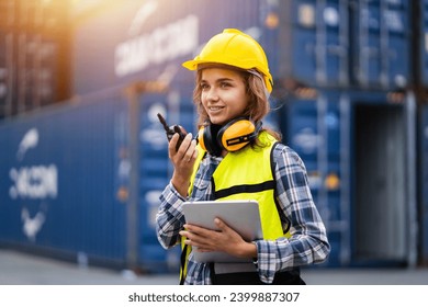 Female workers in the container industry transporting imports and exports of goods to the shipping business. Confident engineer in container terminal. - Powered by Shutterstock