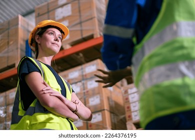 Female workers wearing helmets in logistics distribution warehouse. Group of diversity warehouse worker meeting and checking list inventory in industry factory. Plan and investment concept. - Powered by Shutterstock