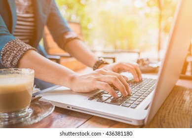 Female working on laptop in a cafe.