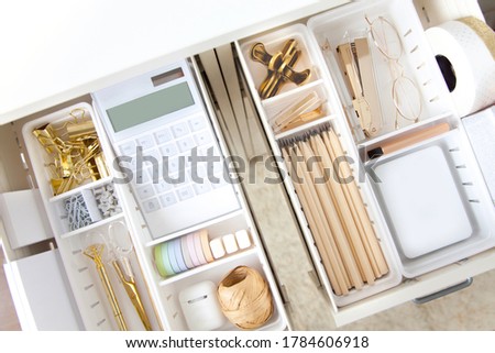 Female workplace. White work table. The stylish gold stationery is arranged very neatly in the drawers of the desk. Japanese storage method.