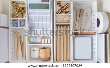 Female workplace. White work table. The stylish gold stationery is arranged very neatly in the drawers of the desk. Japanese storage method.
